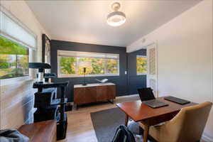 Home office featuring light wood finished floors and healthy amount of natural light