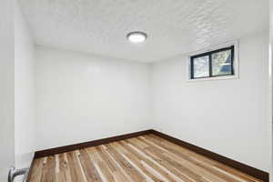 Empty room with a textured ceiling and wood finished floors
