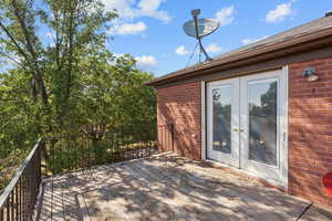 Deck off the the kitchen.  Wooden terrace featuring french doors