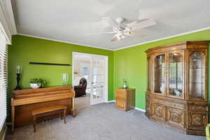 Living area featuring french doors, healthy amount of natural light, carpet flooring, and crown molding