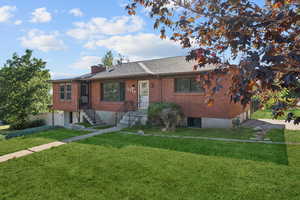 View of front facade featuring brick siding and an attached garage