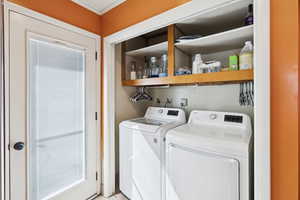 Laundry area featuring washing machine and dryer and crown molding