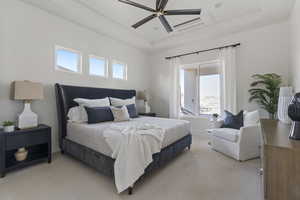 Bedroom featuring a tray ceiling, light colored carpet, and a ceiling fan