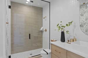 Bathroom featuring tile walls, vanity, and a stall shower
