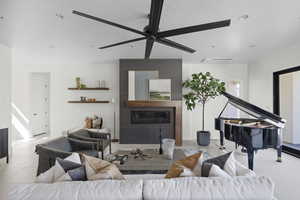 Living room featuring ceiling fan, recessed lighting, a textured ceiling, and a fireplace