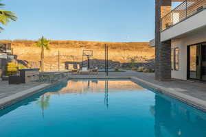 View of swimming pool featuring a patio, a fenced backyard, and a pool with connected hot tub