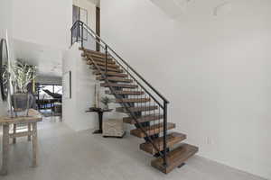 Staircase with a high ceiling and tile patterned floors