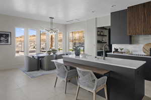Kitchen with dark cabinetry, modern cabinets, and a chandelier