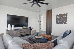 Living room with a ceiling fan and baseboards