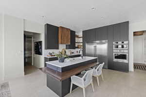 Kitchen featuring open shelves, appliances with stainless steel finishes, modern cabinets, dark cabinetry, and light countertops