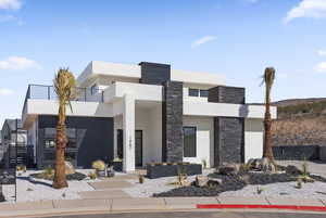 Contemporary house featuring stone siding and stucco siding