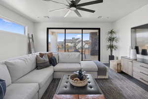 Living area with a ceiling fan and baseboards
