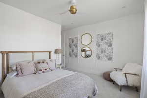 Carpeted bedroom with a ceiling fan