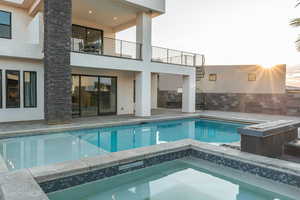 View of pool with a pool with connected hot tub and a patio area