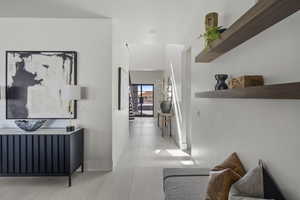 Hall featuring tile patterned floors and baseboards