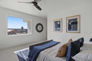 Carpeted bedroom with a ceiling fan
