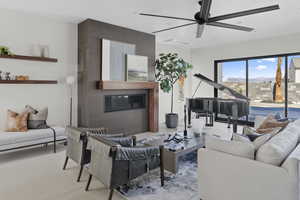 Living area featuring a ceiling fan and a large fireplace