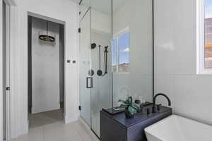 Bathroom featuring a shower stall, a soaking tub, and tile patterned flooring