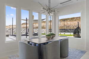 Dining room with healthy amount of natural light, a chandelier, and a mountain view