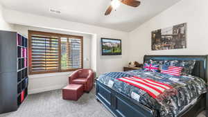 Carpeted bedroom with lofted ceiling and ceiling fan