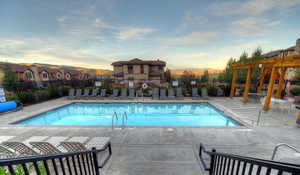 Community pool with a pergola, a patio, and a mountain view