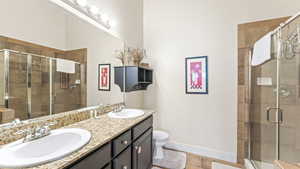 Full bathroom with double vanity and a stall shower