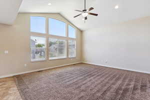 Empty room featuring a ceiling fan, high vaulted ceiling, light carpet, and recessed lighting