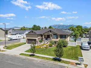 View of front of property featuring stucco siding, driveway, a mountain view, and a garage