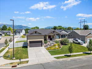 View of front of property with a residential view, driveway, a mountain view, stucco siding, and a garage