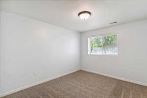 Empty room with carpet floors and a textured ceiling