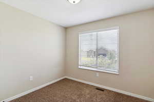Carpeted empty room featuring baseboards