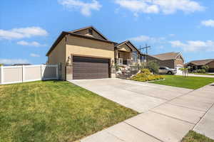 Ranch-style house featuring an attached garage, stucco siding, driveway, a gate, and a residential view