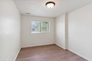 Empty room featuring light wood-type flooring and baseboards