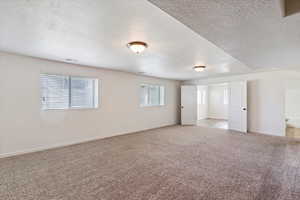 Carpeted empty room featuring a textured ceiling