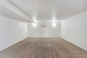 Empty room with carpet floors and baseboards