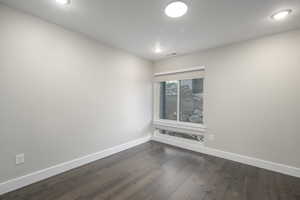 Spare room featuring dark wood finished floors and recessed lighting
