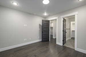 Unfurnished bedroom featuring a walk in closet, dark wood-style floors, and recessed lighting