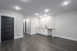 Below grade area with dark wood-type flooring and recessed lighting