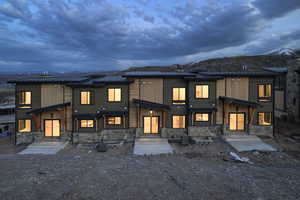 Back of property with a standing seam roof, stone siding, a metal roof, and a mountain view