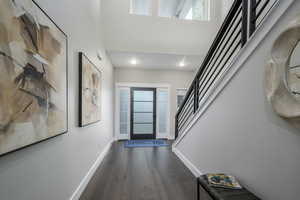 Entrance foyer featuring stairs, dark wood-style floors, and recessed lighting