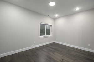 Spare room with baseboards and dark wood finished floors