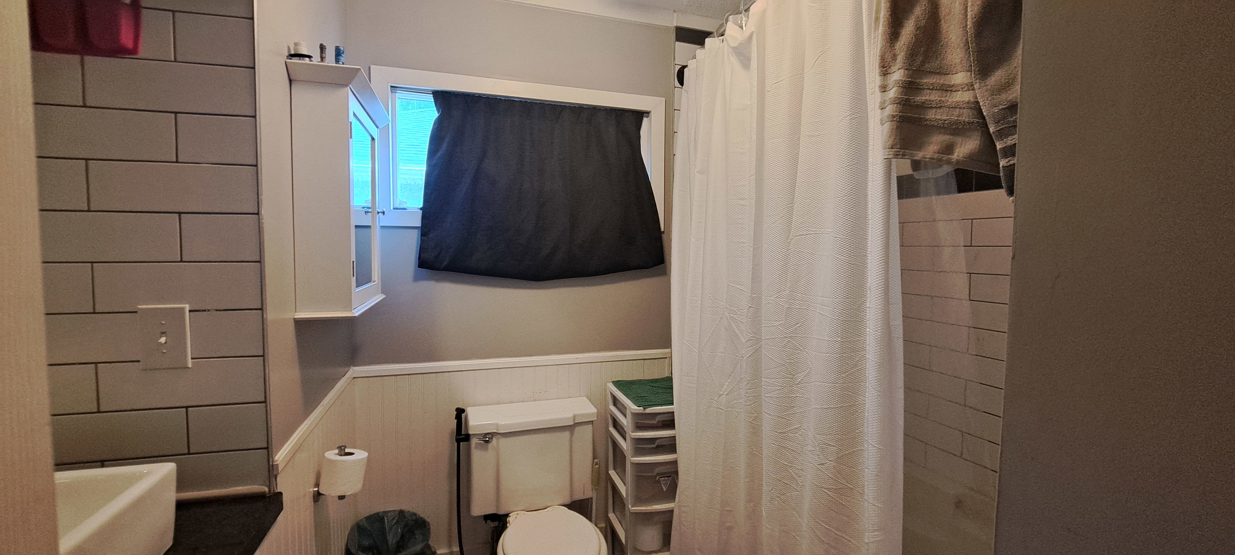 Bathroom featuring wainscoting and curtained shower