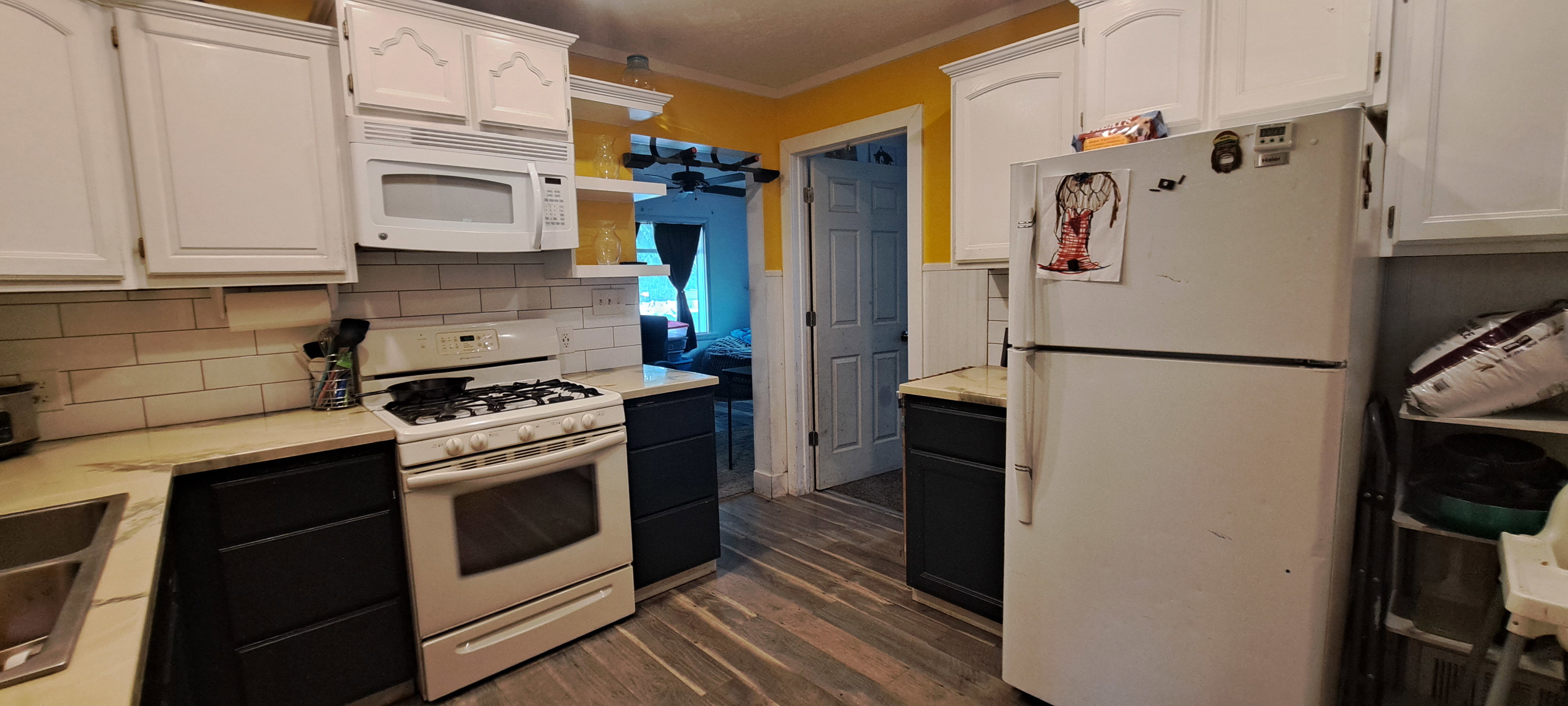 Kitchen with white appliances, white cabinets, crown molding, dark wood-style floors, and light countertops