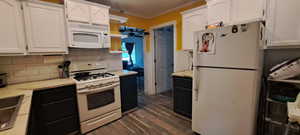 Kitchen with white appliances, white cabinets, crown molding, dark wood-style floors, and light countertops