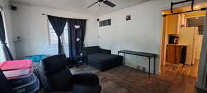 Sitting room featuring ceiling fan, ornamental molding, and wood finished floors