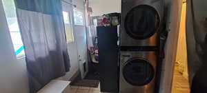 Washroom with stacked washer / dryer and tile patterned flooring
