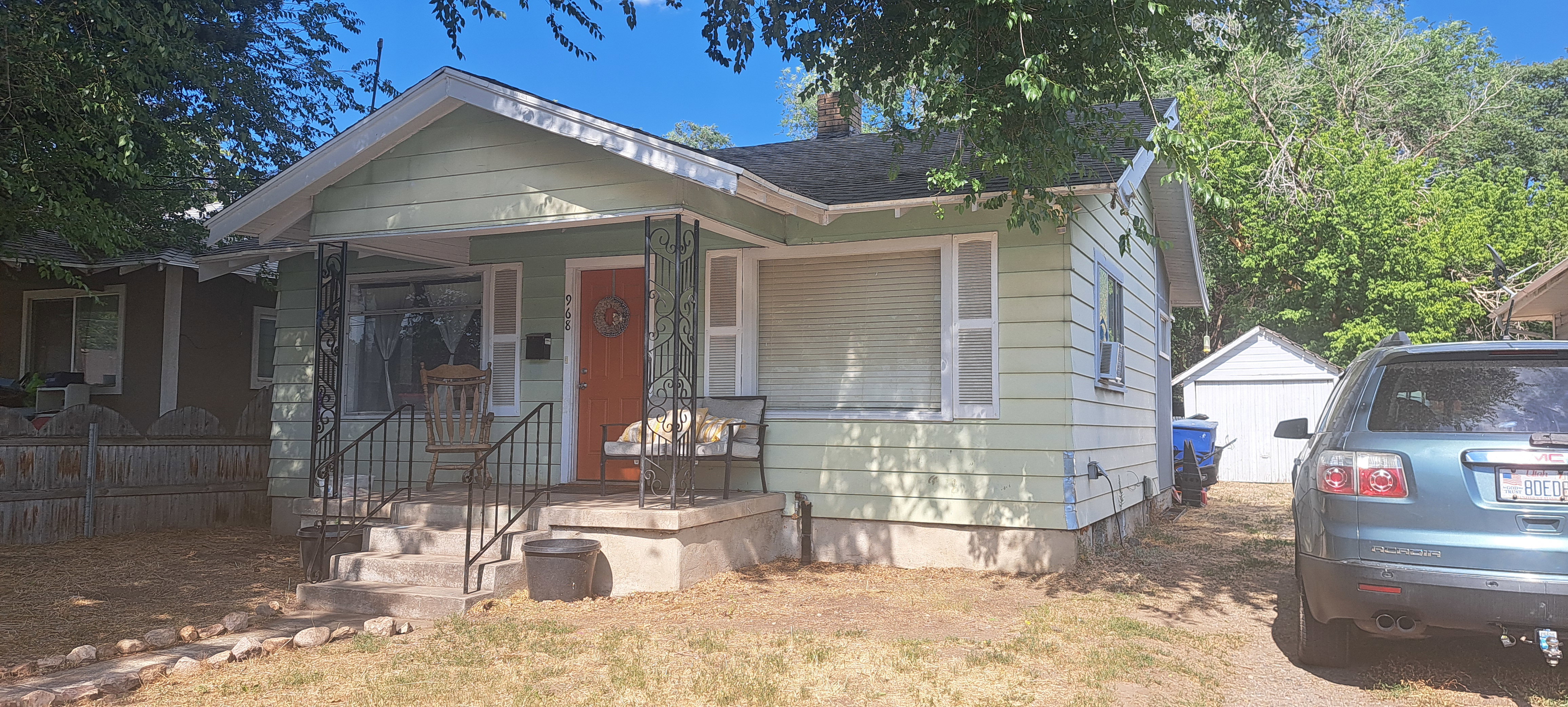 View of front of home with roof with shingles and an outbuilding