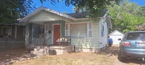 View of front of home with roof with shingles and an outbuilding