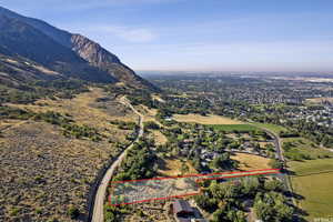 Aerial view of property and surrounding area featuring property boundaries highlighted and a mountain backdrop