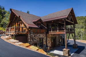 View of front facade with stone siding, a standing seam roof, and a metal roof